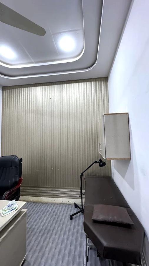 Treatment room with examination couch and lamp at Al-Shama Physiotherapy Clinic, Khanpur